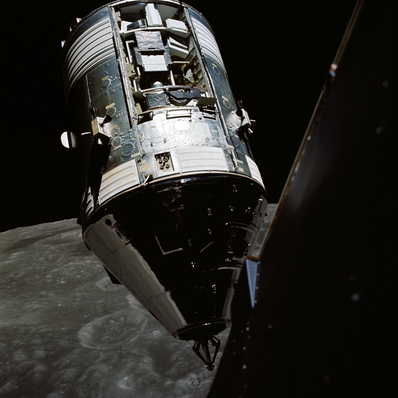 a shiny silver module floats above the surface of a cratered moon