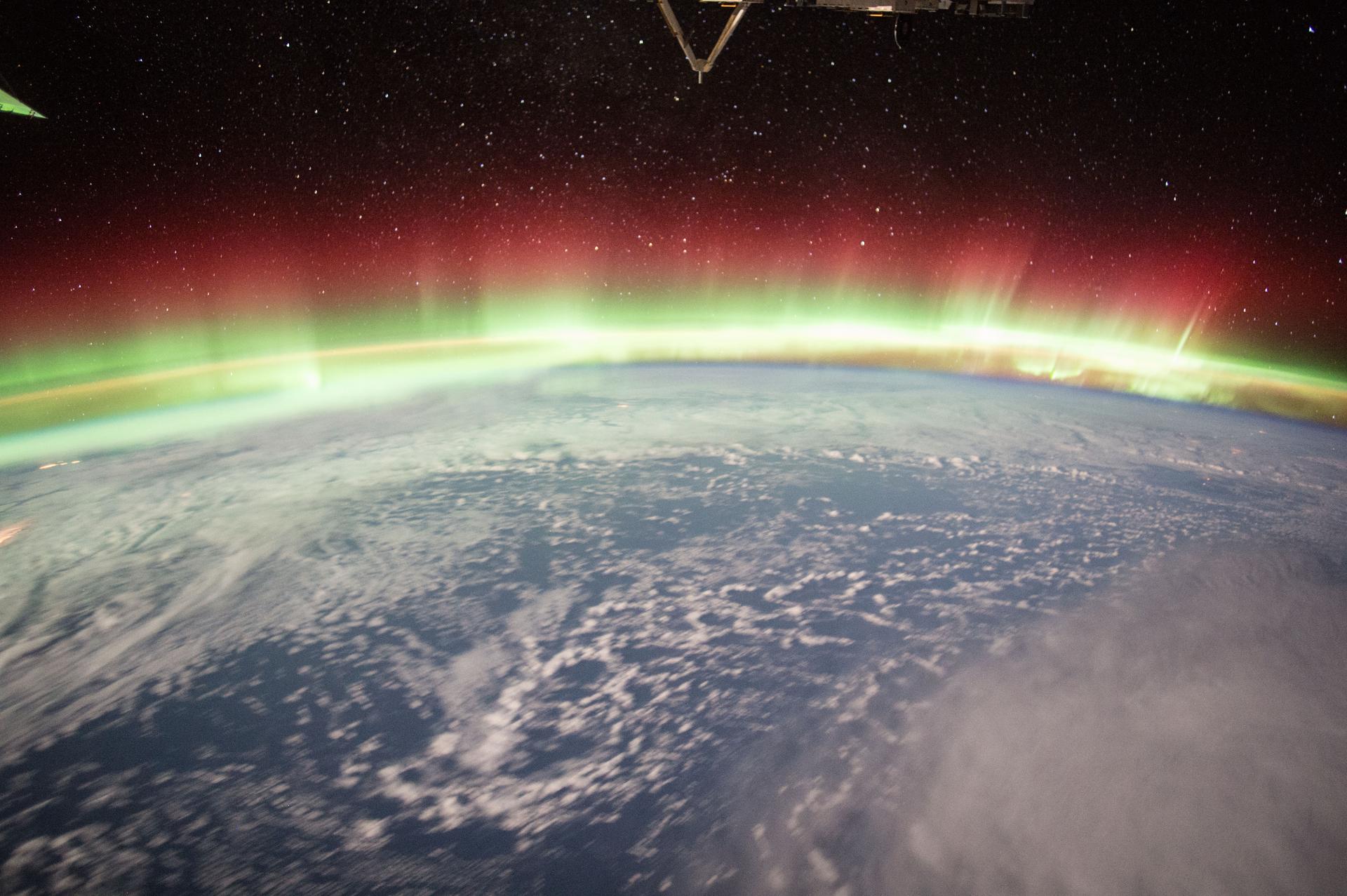 red and green aurora over a blue ocean