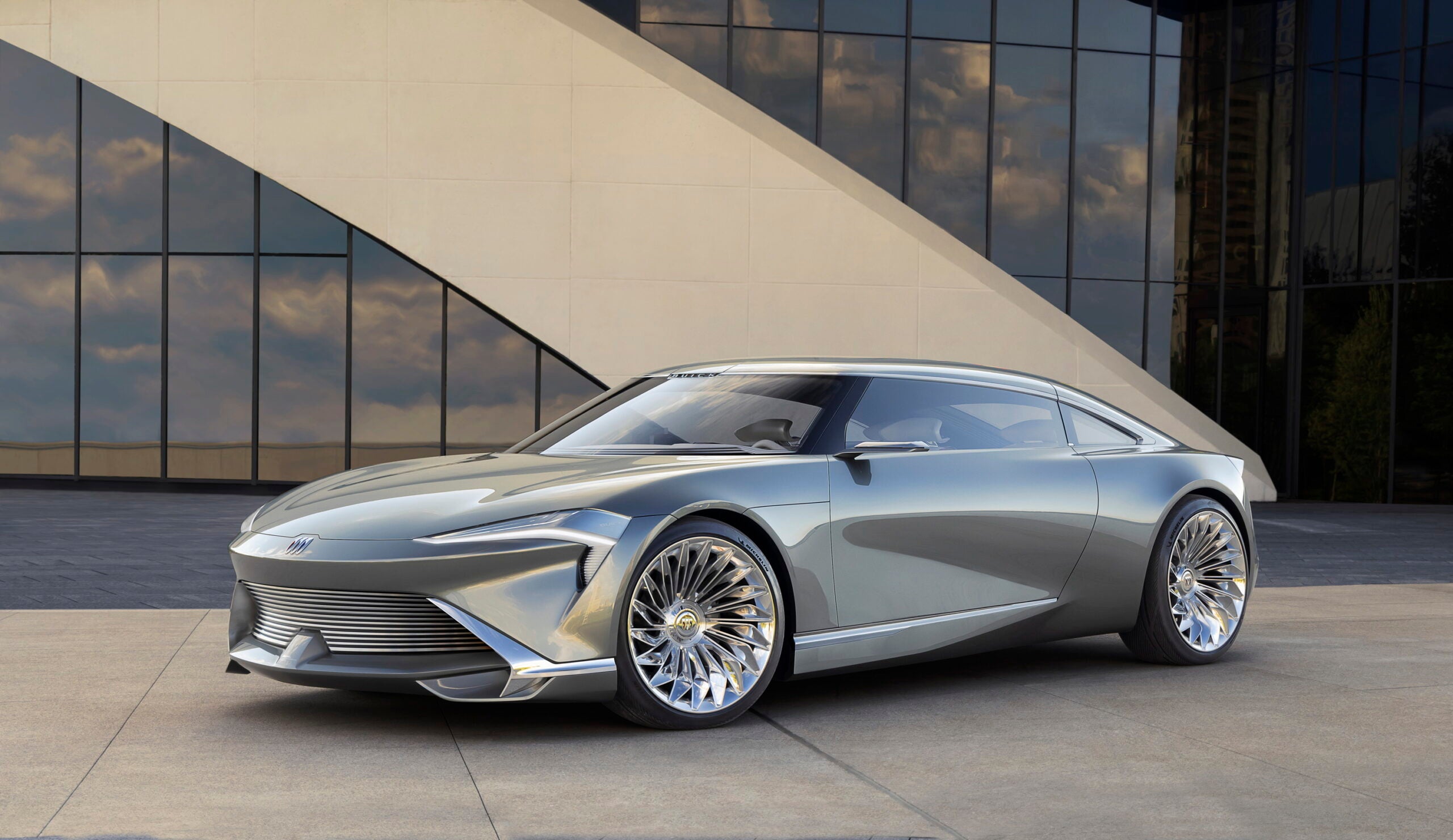 a shiny silver car in front of an office building