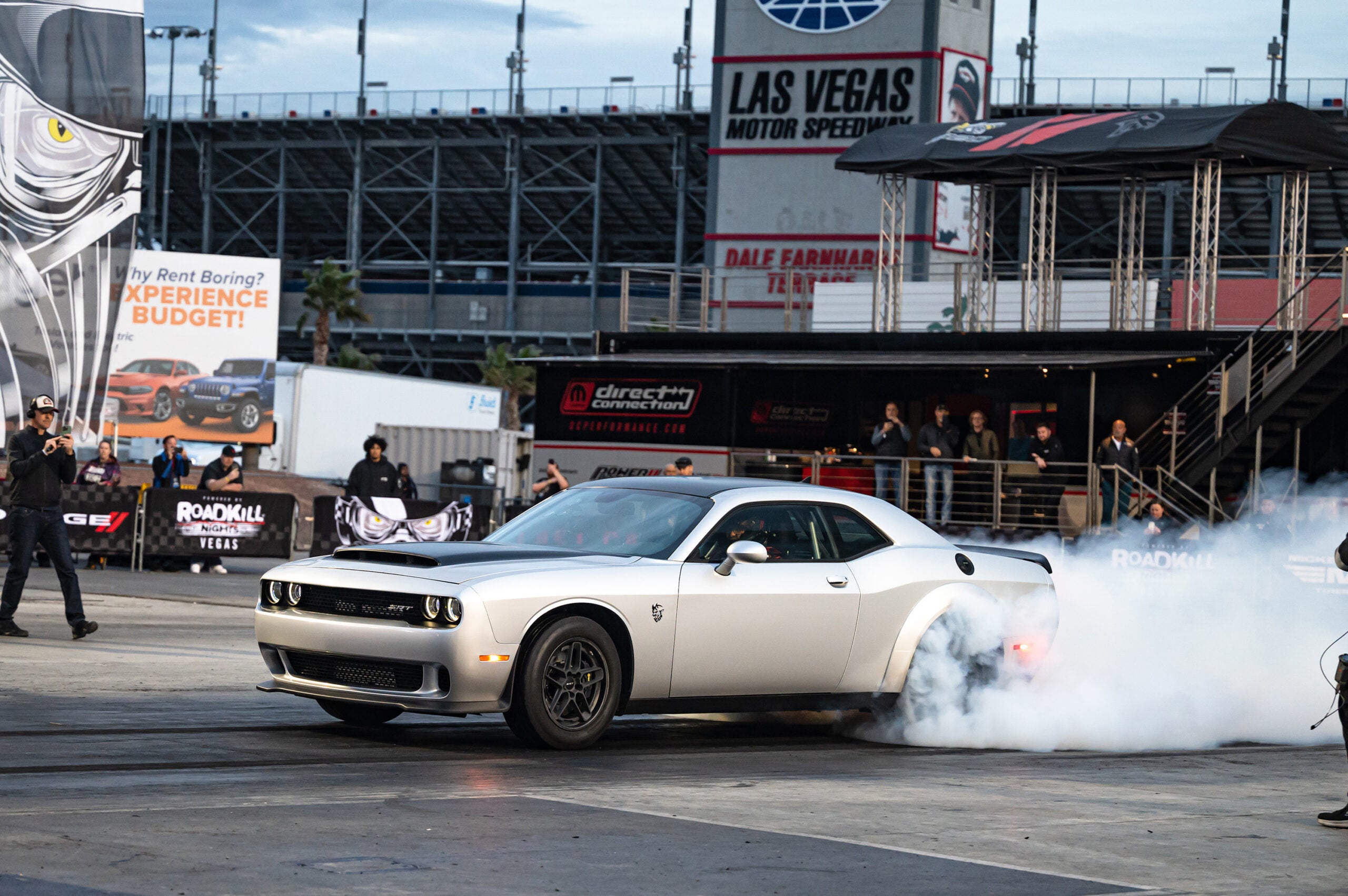 a silver car with steam emerging from its back wheels