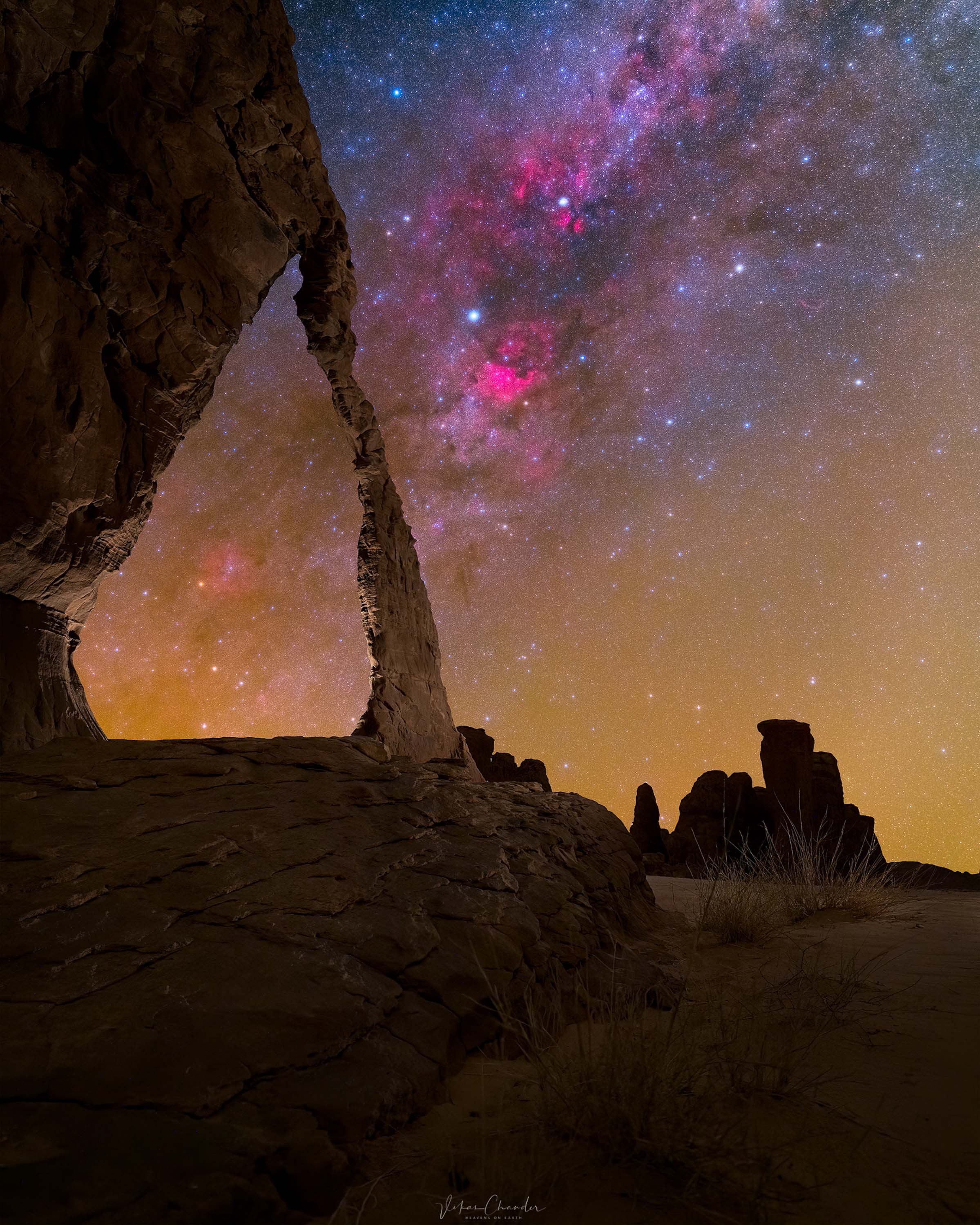 rocky structures including an arch with many stars in the sky