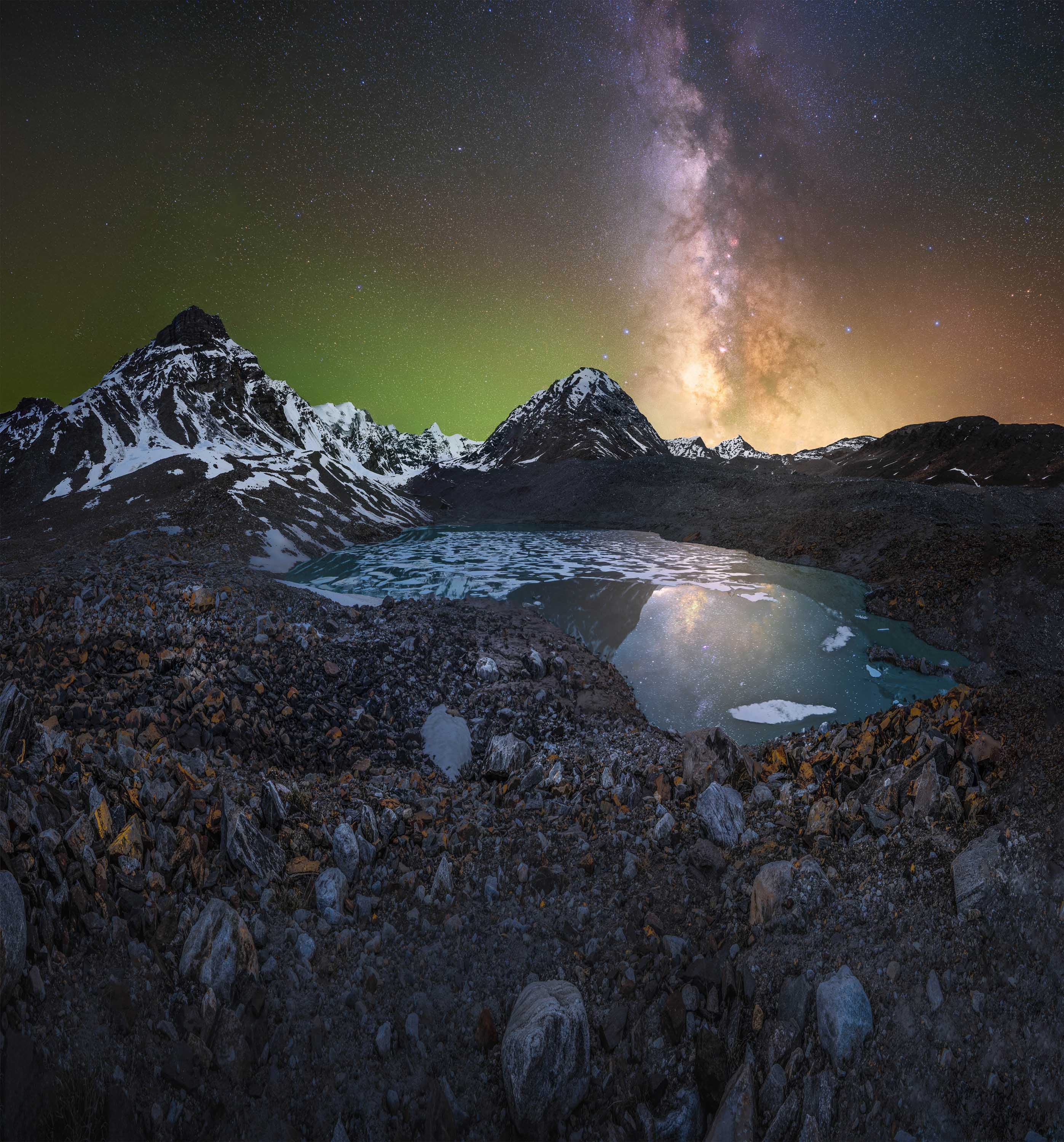 snowy mountains with a mountain lake and milky way stretched across. the sky