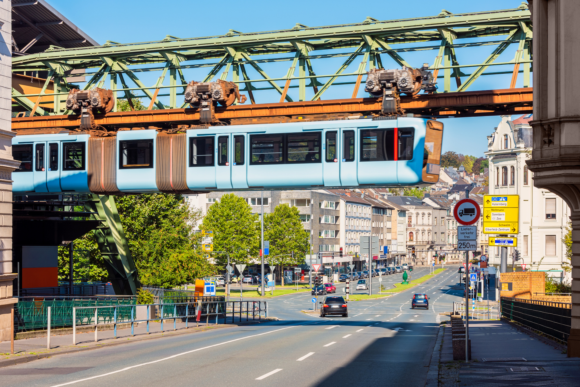 Schwebebahn Train Crossing a Street in Wuppertal, Germany. The Schwebebahn is the oldest electric elevated railway with hanging cars in the world and is a unique system in Germany. It is active since 1901.