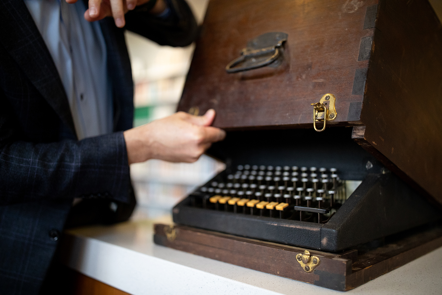 Man closing case on Chinese typewriter prototype