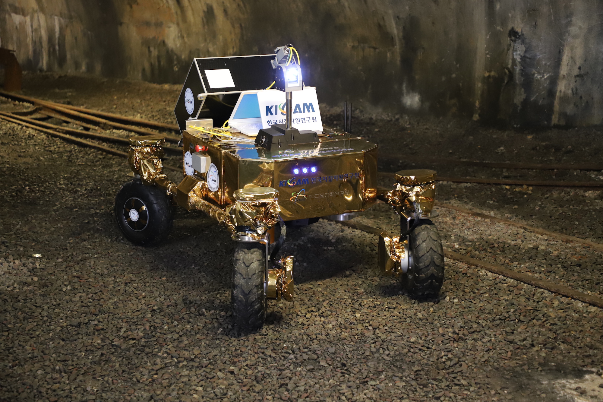 a rover rolling on rocks in a mine near tracks