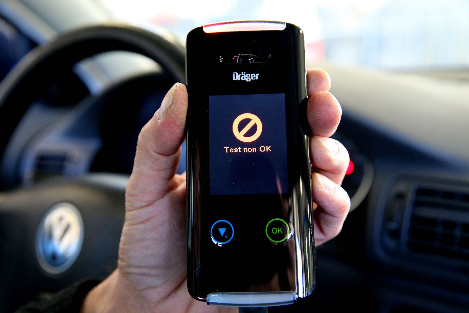 A man holds an electronic ethylotest device that prevents the start of the vehicle in case of positive control, in Reims, northeastern France, on December 1, 2016. This device is tested in several French departments from December 1 and will be mandatory for people in case of a positive test. The lettering on the display reads 'Test not okay'.