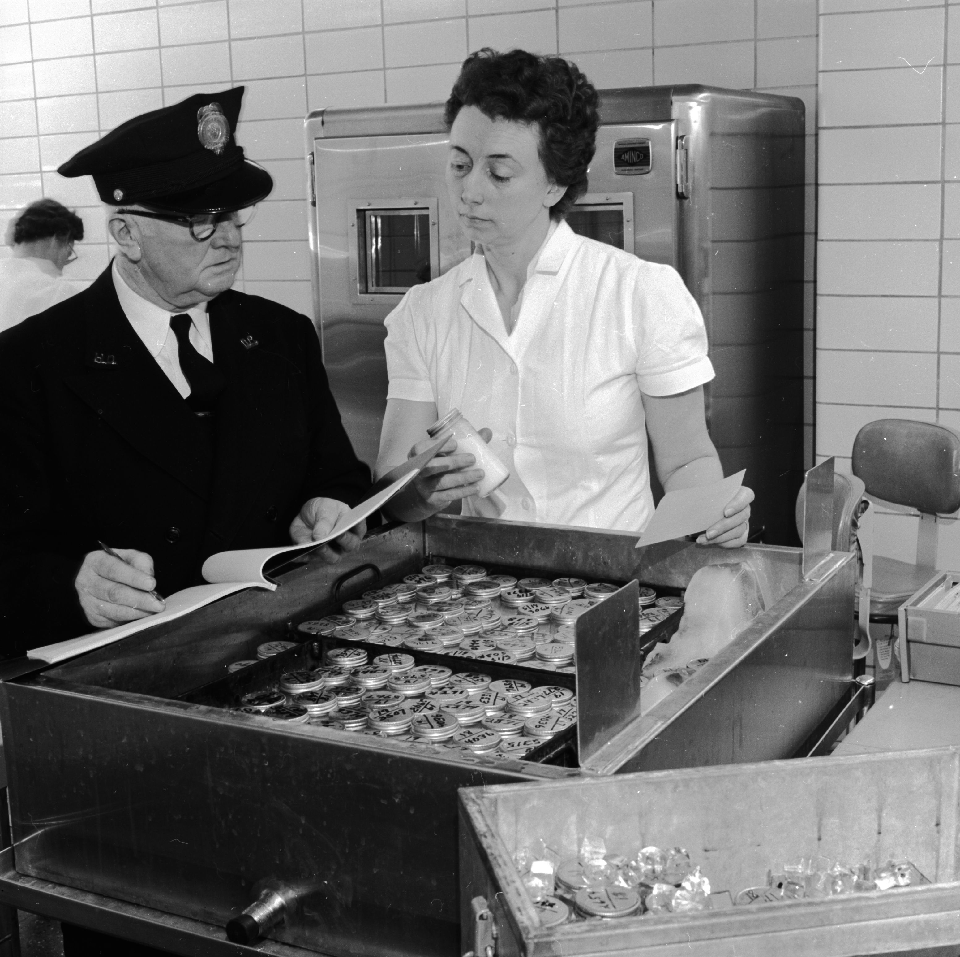 circa 1955: Hubert E Mills of the Department of Pasteurized Dairy Products and Dora Morris, technician for the Maryland and Virginia Milk Products Association, checking samples taken from a farm for purity. (Photo by Evans/Three Lions/Getty Images)