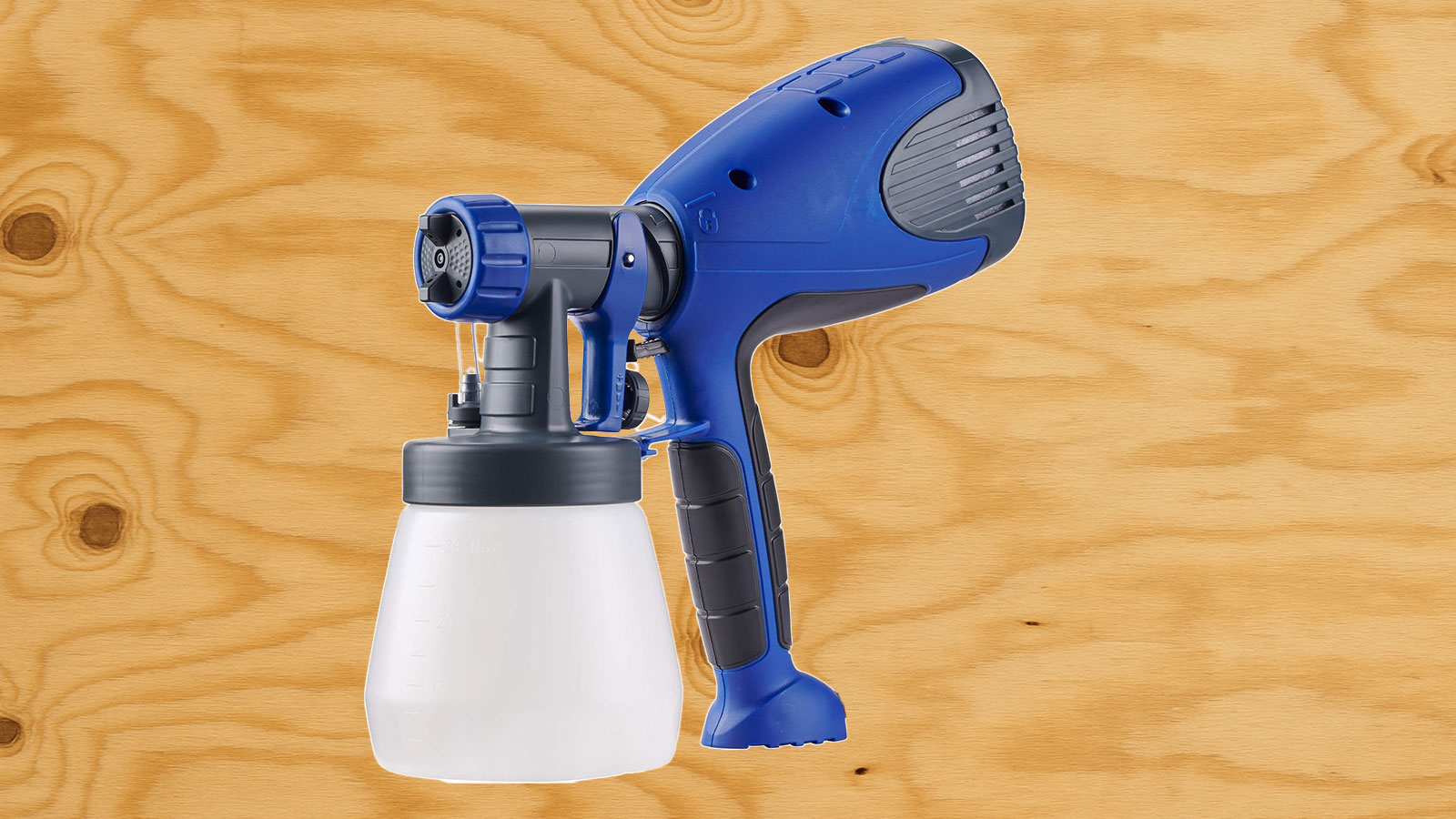  A HomeRight paint sprayer in front of plywood.