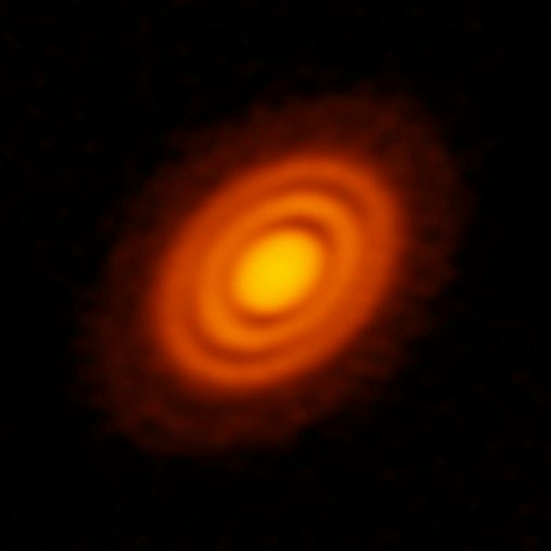 A protoplanetary disk in space, featuring a bright star in the center, reflecting yellow light, and surrounded by swirls of orange dust.