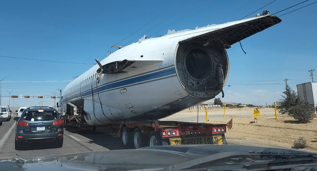 a plane fuselage on a flatbed truck