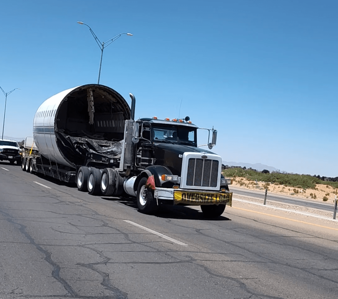 a plane fuselage on a flatbed truck