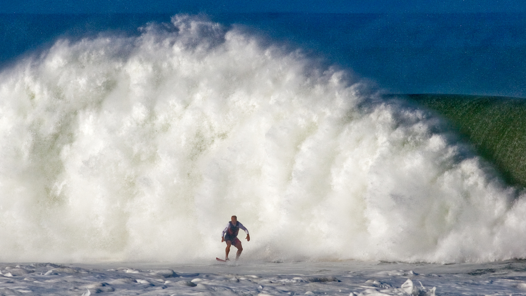 Large ocean wave crashing behind tow in surfer at Zicatela Beach, Puerto Escondido, Oaxaca, Mexico.