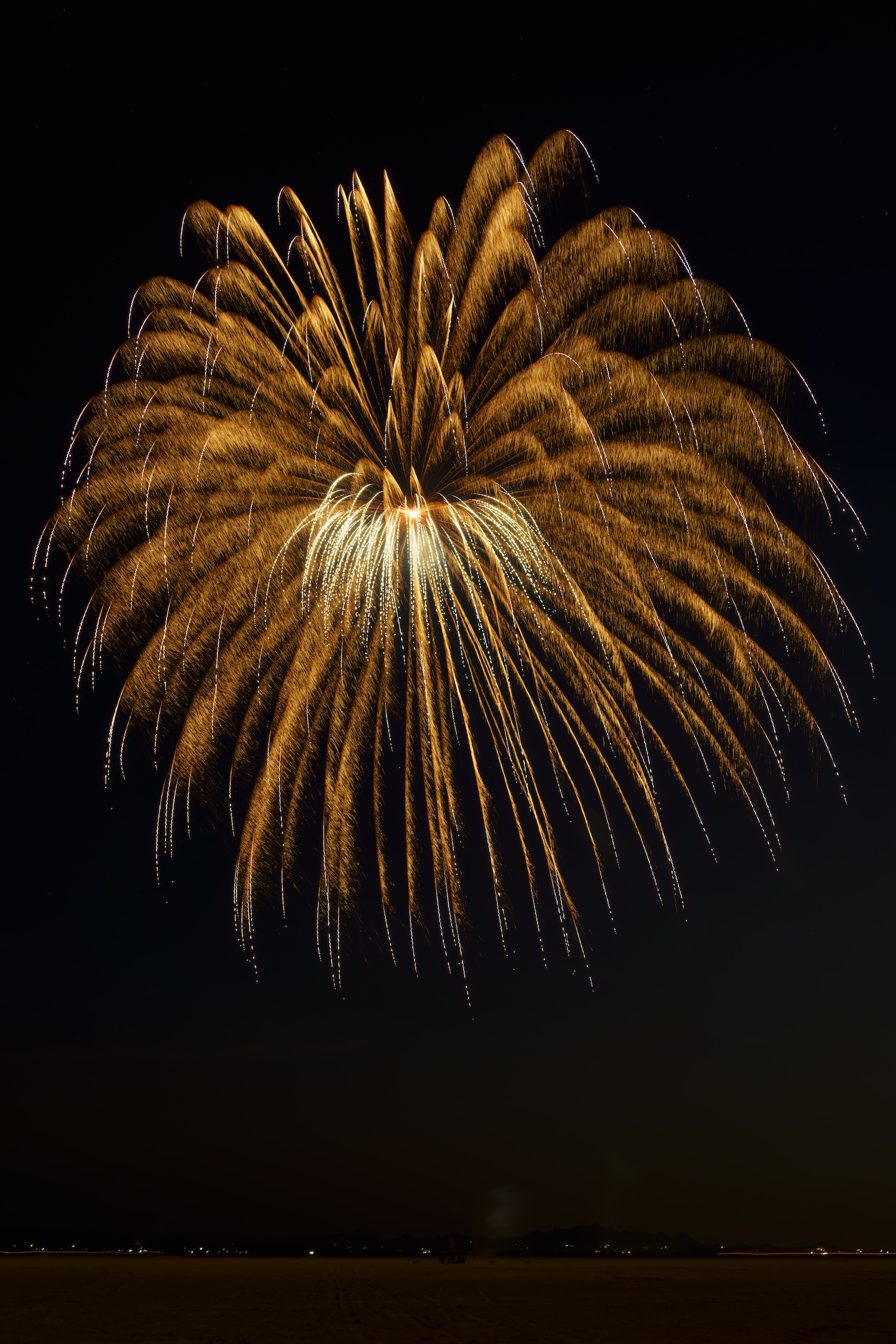 Red and orange firework exploding in desert at night