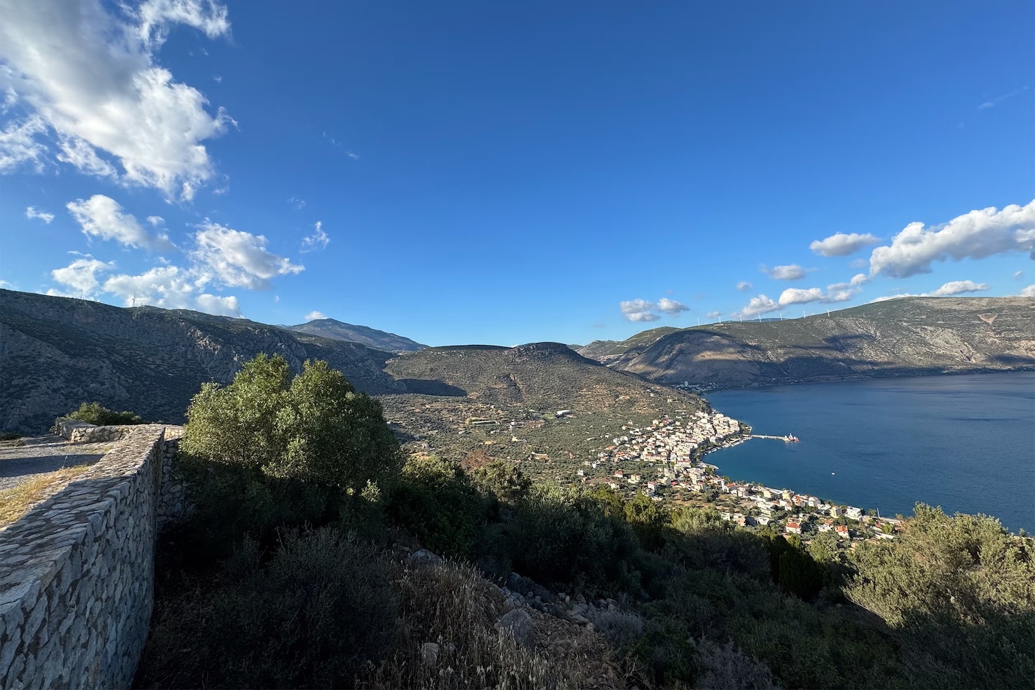 A view of Antikyra, Greece, that shows a small town amid mountains on a bay