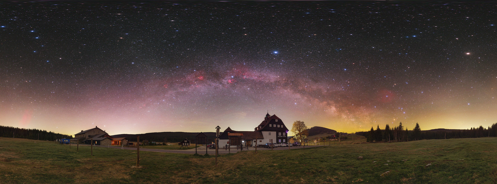 the milky way stretches over a rural landscape