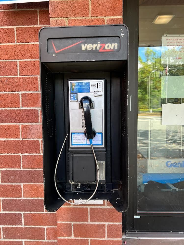 a refurbished payphone on a brick wall