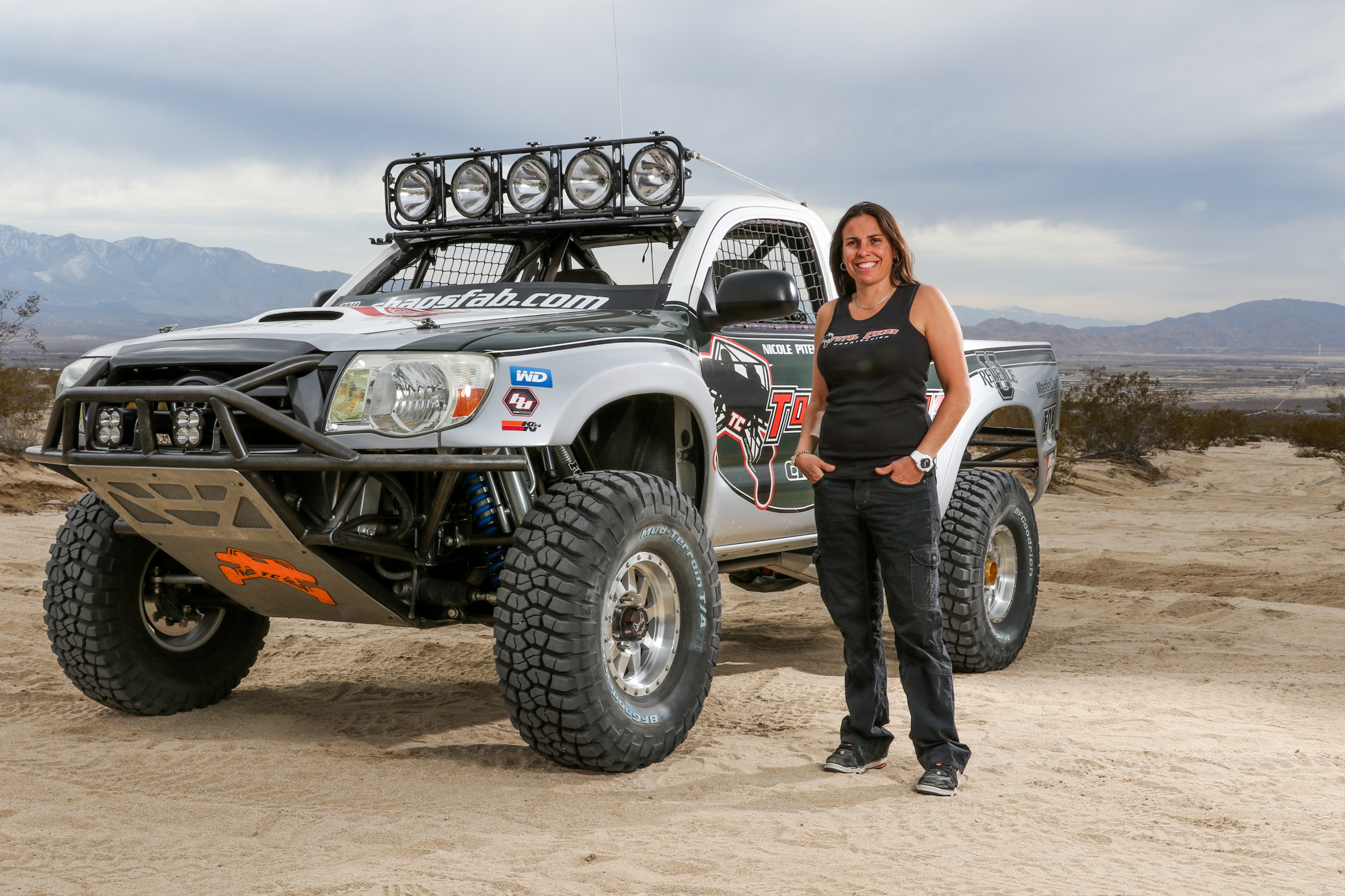 woman stands next to truck
