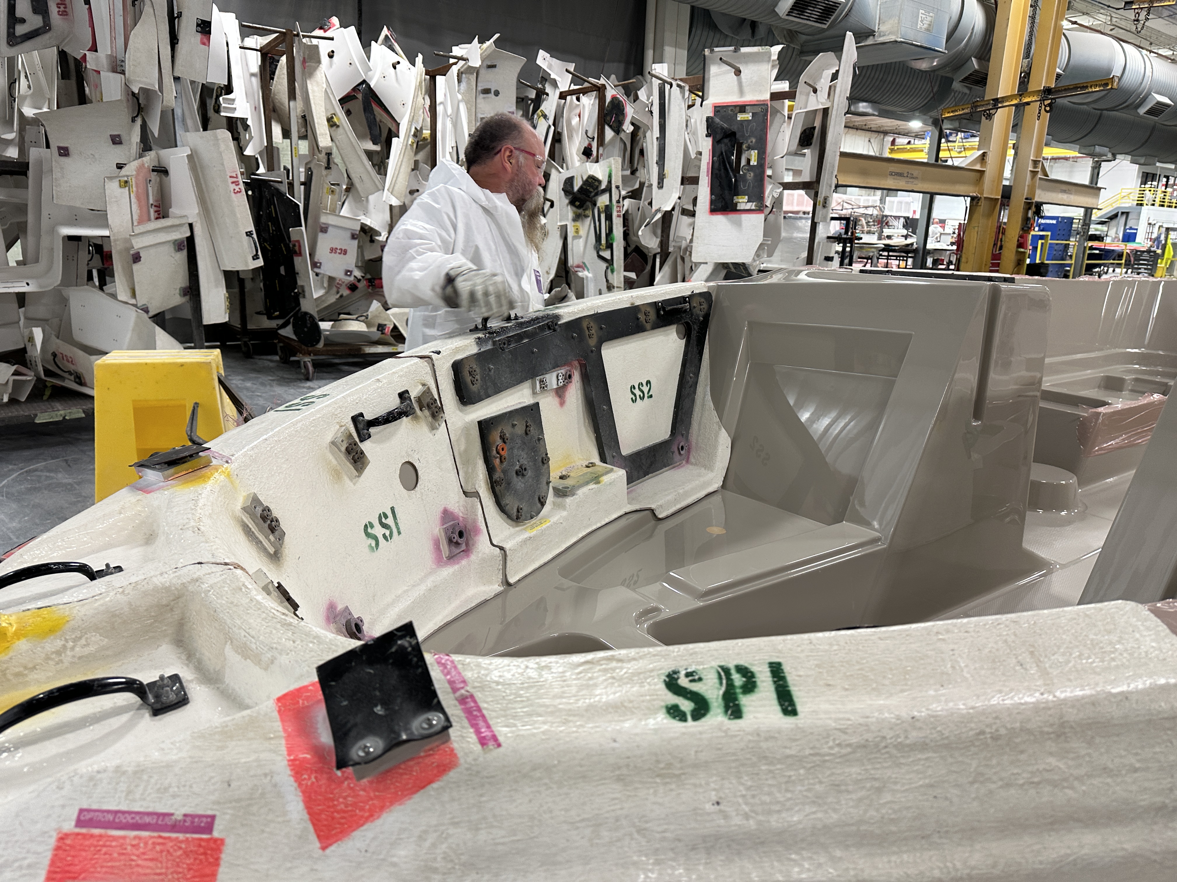 man works on boat in assembly line