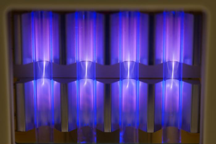 four UV lamps with blue and violet light on a ceiling