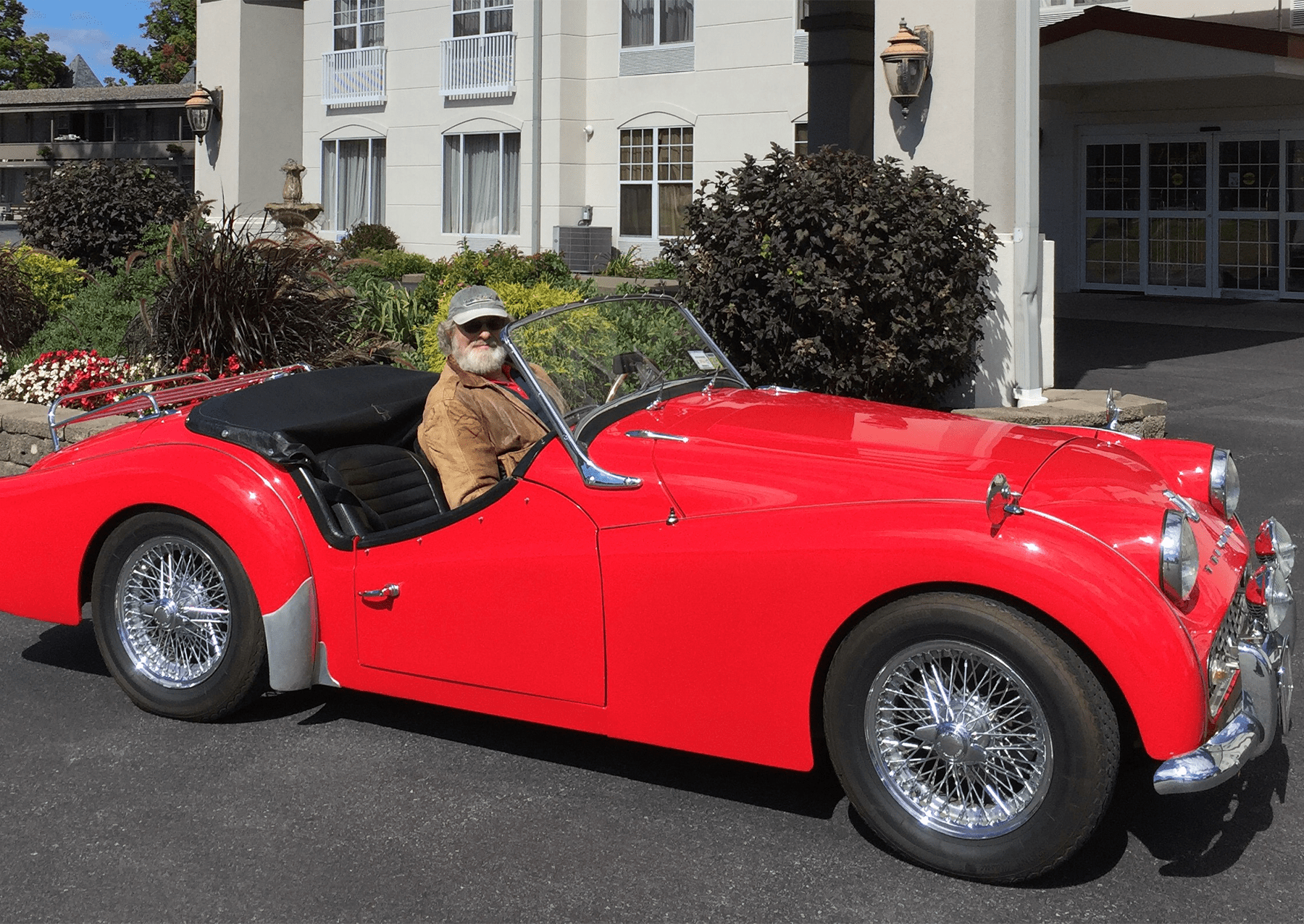 a man driving a red car