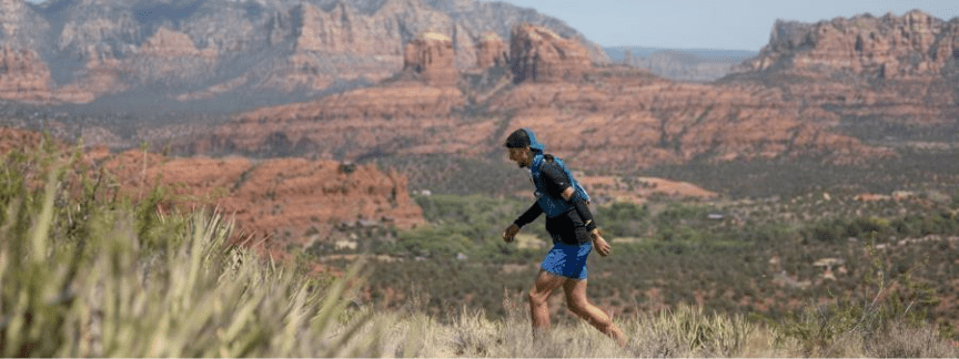 a many running with towering red rocks