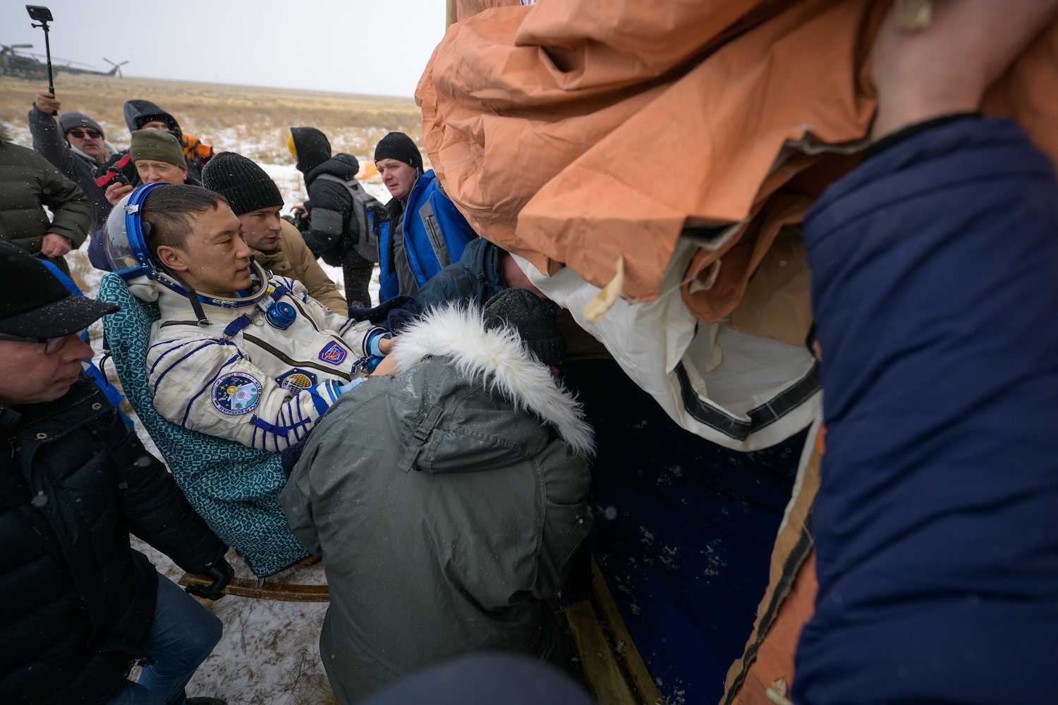 NASA astronaut Jonny Kim is carried to a medical tent shortly after he, and Roscosmos cosmonauts Sergey Ryzhikov, and Alexey Zubritsky, landed in their Soyuz MS-27 spacecraft near the town of Zhezkazgan, Kazakhstan on Tuesday, Dec. 9, 2025. The trio returned to Earth after logging 245 days in space as a members of Expeditions 72 and 73 aboard the International Space Station. Credit: NASA / Bill Ingalls