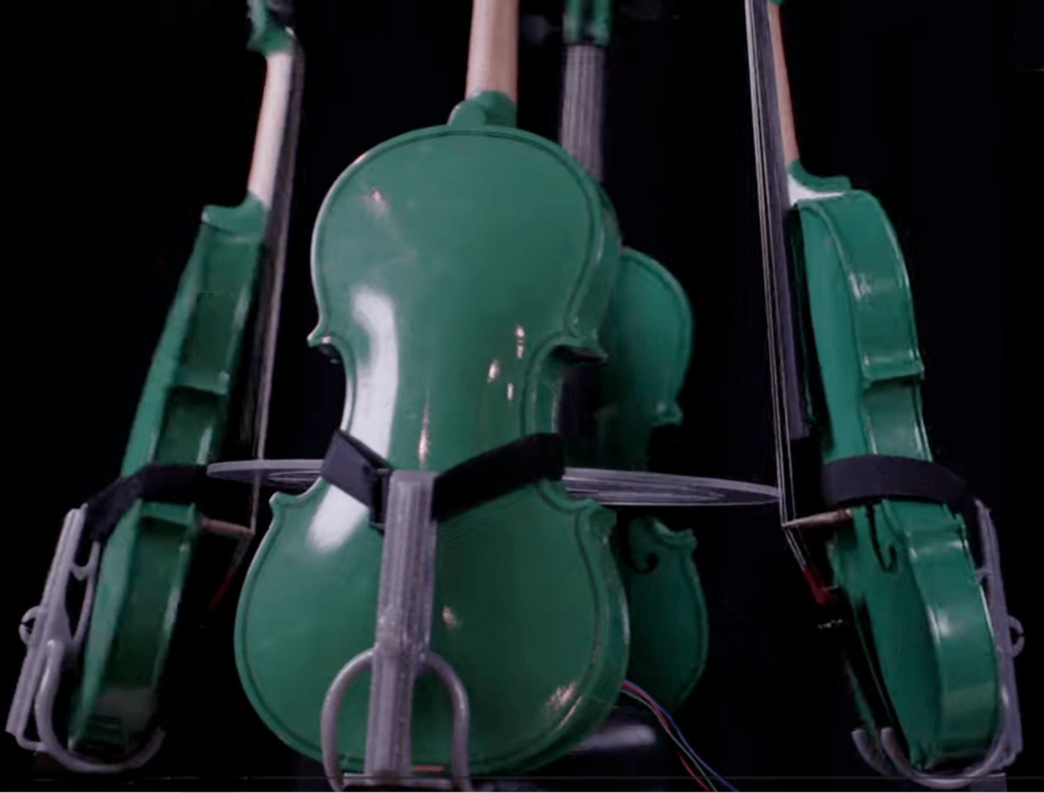 Four green fiddles attached around a circular center piece