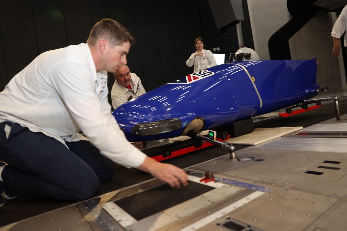 engineers working on a blue bobsled