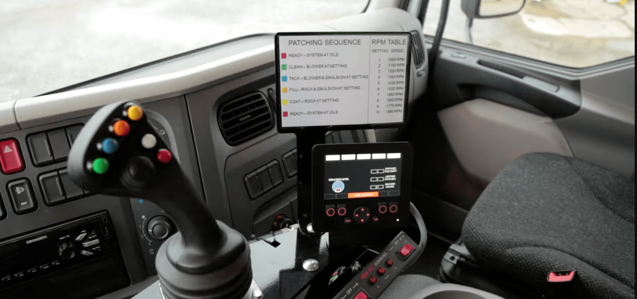 the inside of a truck with joystick controller and screens