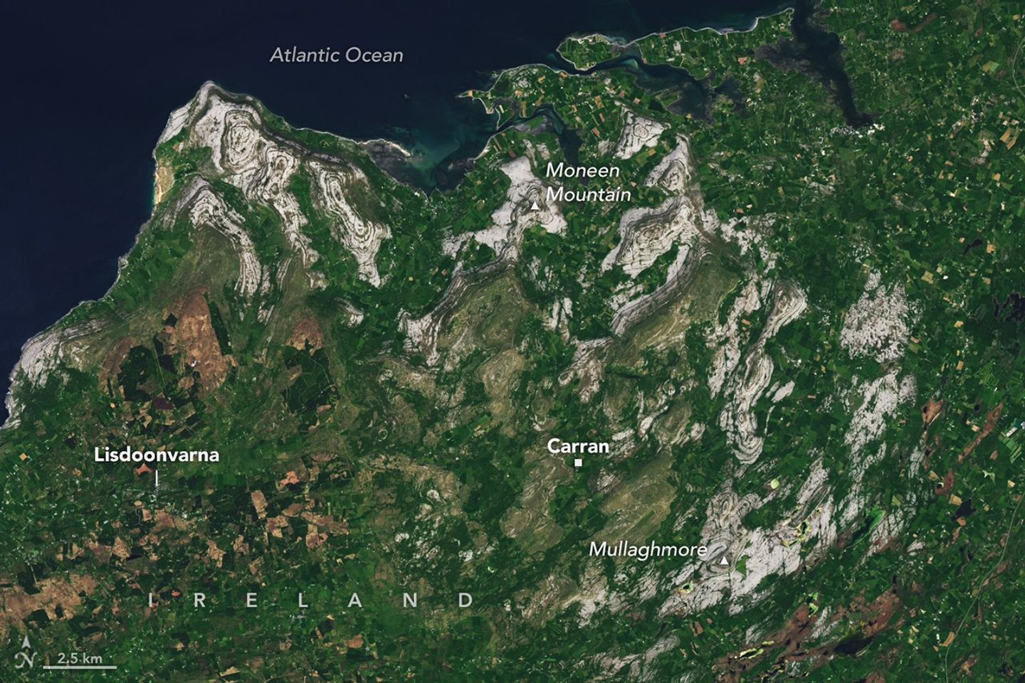 a sattelite image of the west coast of ireland showing gray outcroppings of limestone amidst green 
