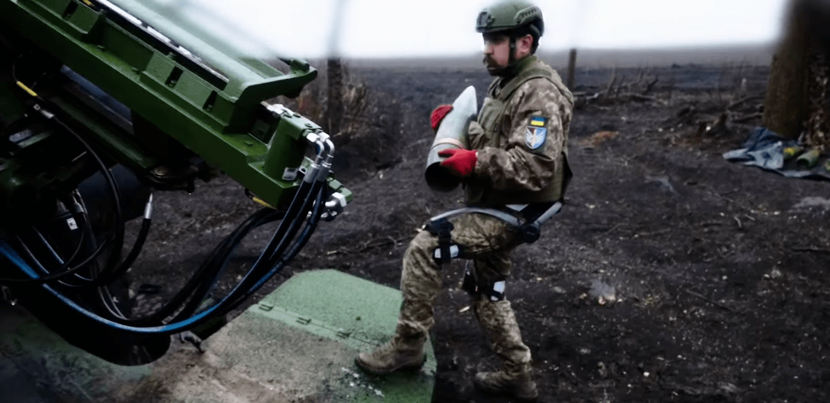 a soldier loading an artillery shell